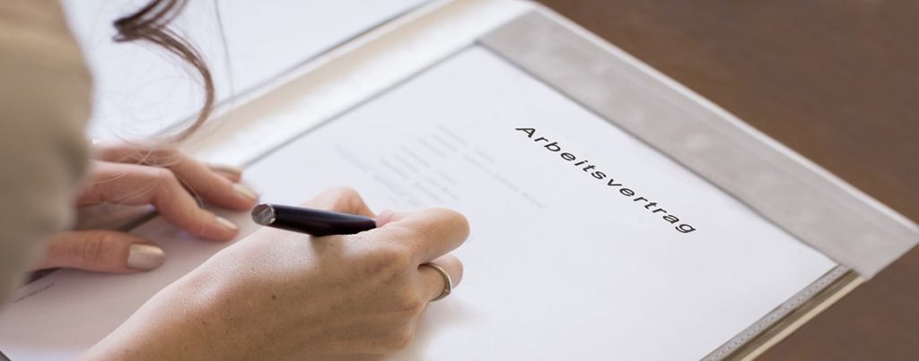 Frau unterschreibt Arbeitsvertrag