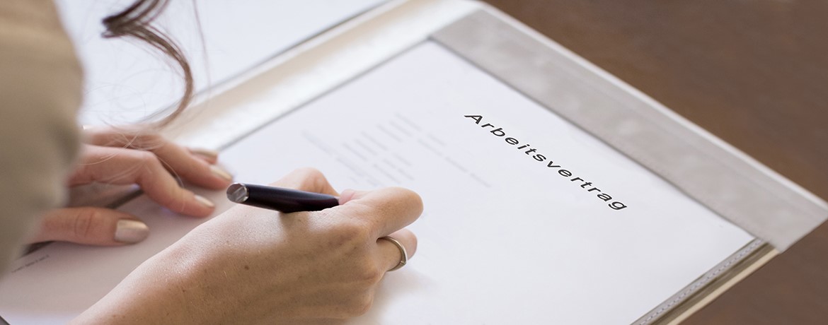 Frau unterschreibt Arbeitsvertrag