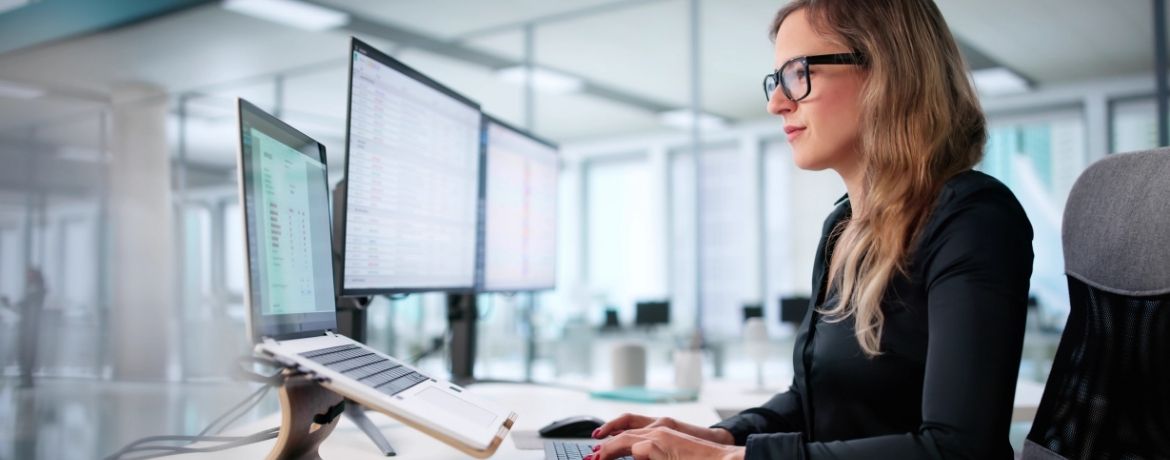 Frau an Bildschirmen bei digitaler Arbeit